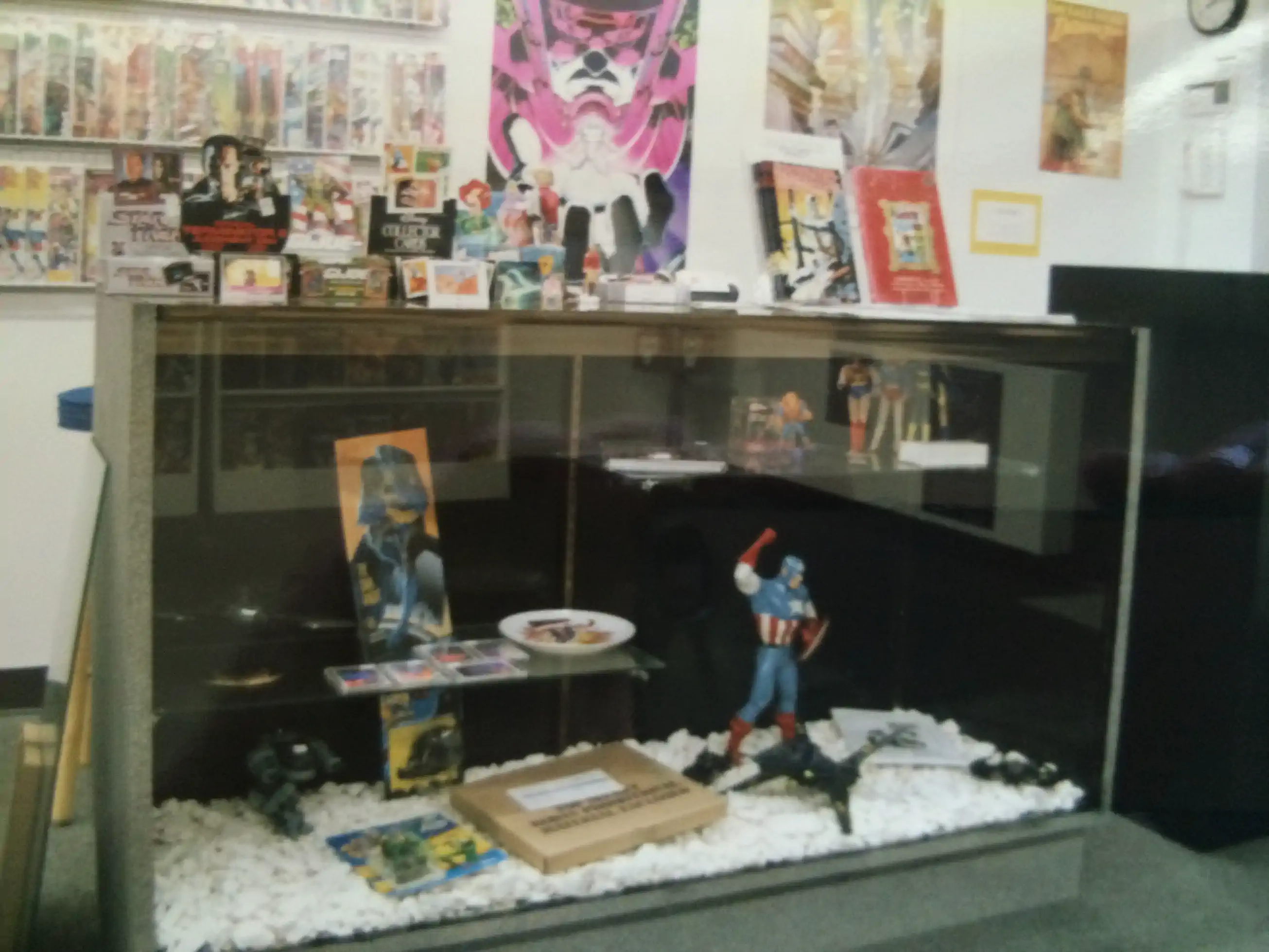 A close-up of a display case at Rocket Comics, showcasing a variety of collectibles and back issues.