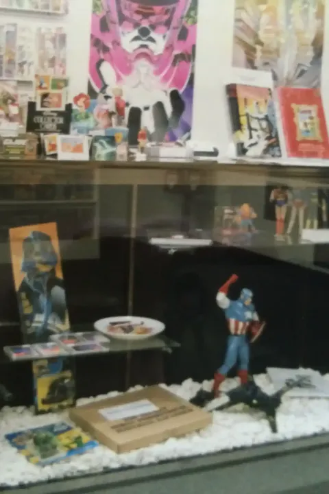 A close-up of a display case at Rocket Comics, showcasing a variety of collectibles and back issues.